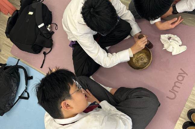 Secondary school students exploring a singing bowl