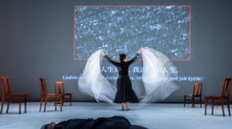 Helen performing on stage, white fabric caught mid-movement